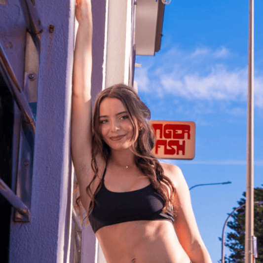 Teen wearing period swim crop top and bikini bottom set