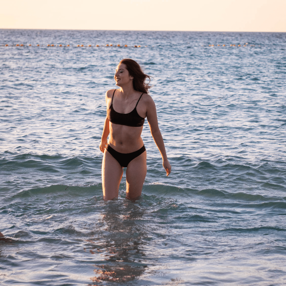 Teen wearing period swim crop top and bikini bottom set